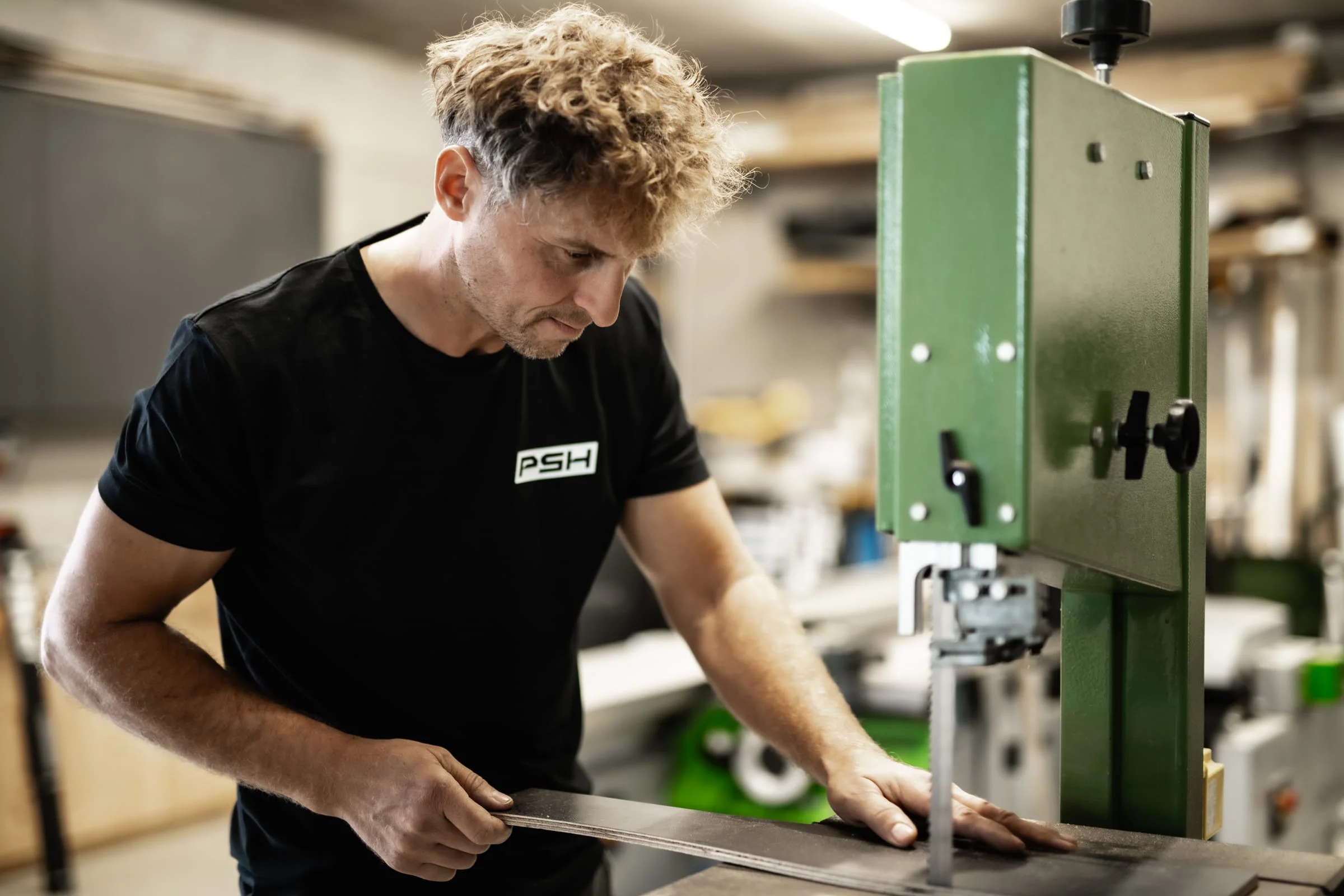 Michael Höller schneidet ein Bauteil an der Bandsäge zu